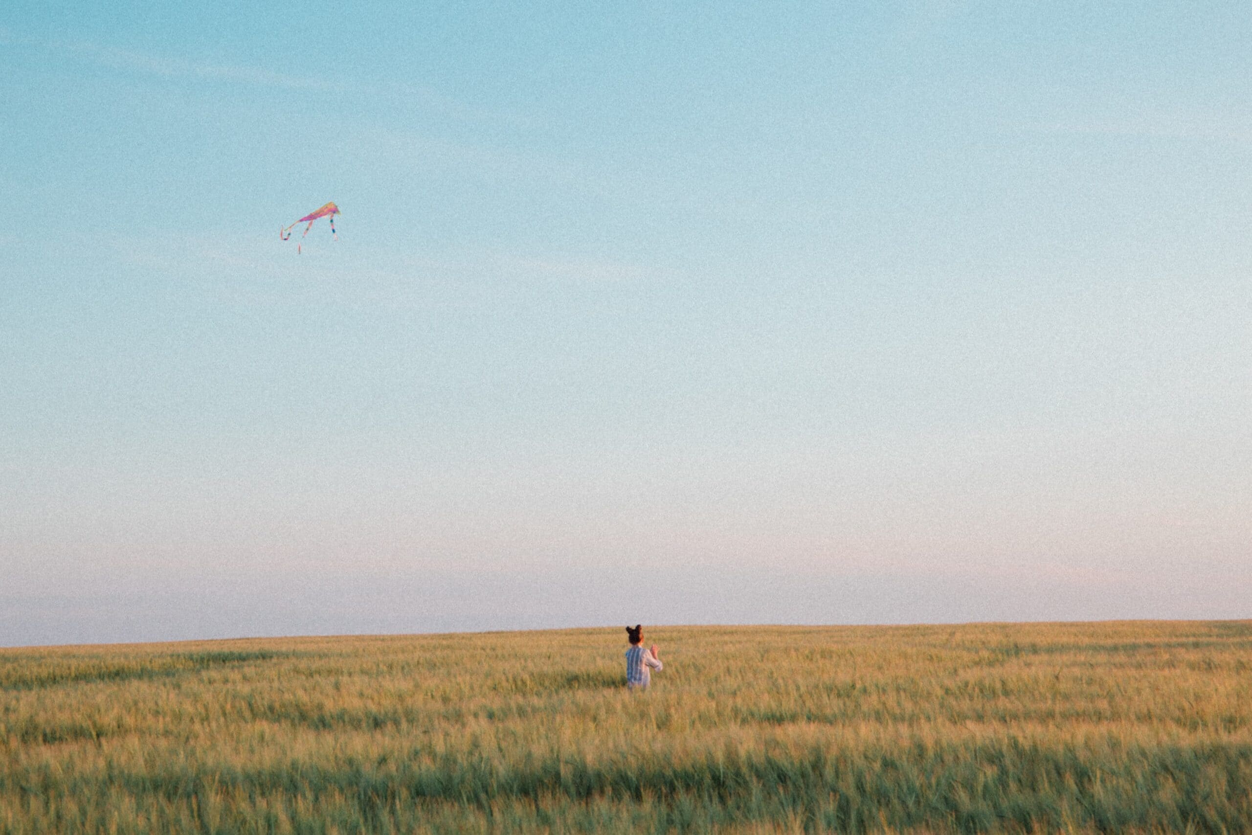 Das Kind spielt auf dem Feld mit Luftballon